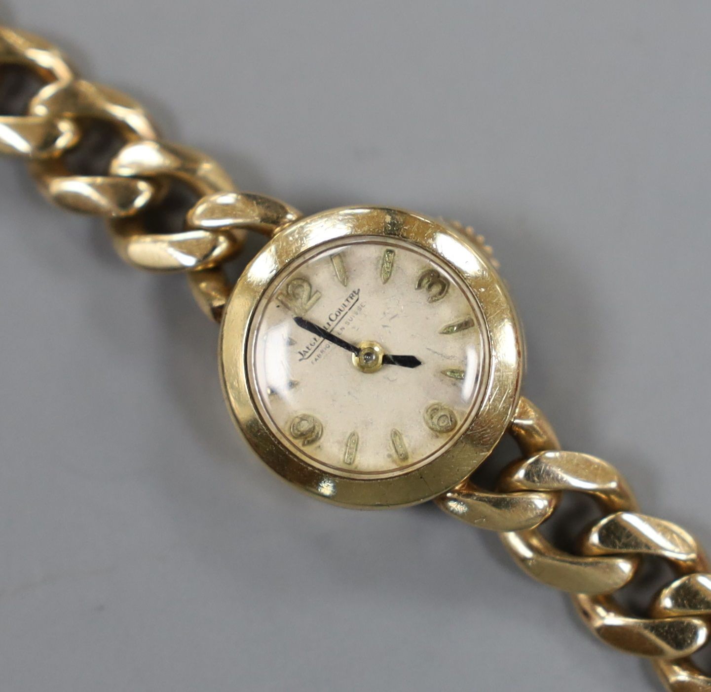 A lady's 1960's 9ct gold Jaeger Le Coultre back wind wrist watch, on a 9ct gold curb link bracelet